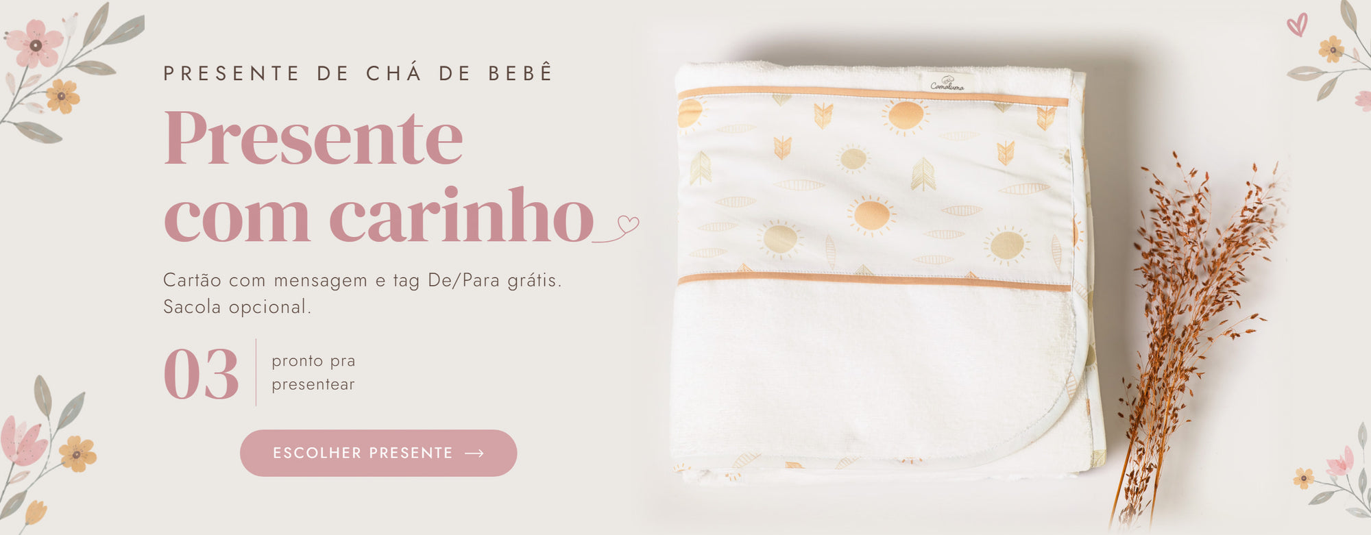 Toalha de banho Camaluma estampa sol, dobrada sobre fundo creme com raminho seco